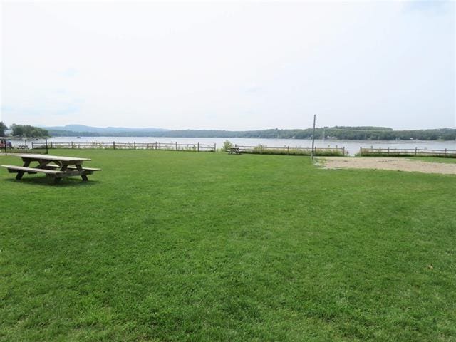 view of yard with a water view and fence