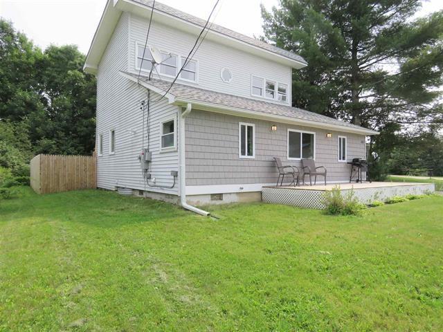 back of property featuring fence and a lawn