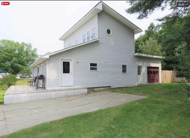 back of house featuring a lawn, a wooden deck, and fence