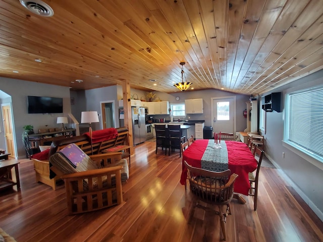 dining area with lofted ceiling, visible vents, baseboards, and wood finished floors