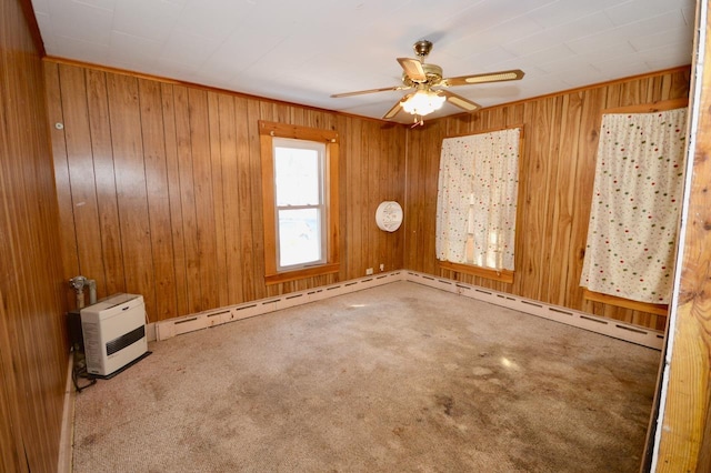 carpeted spare room with a ceiling fan and wood walls