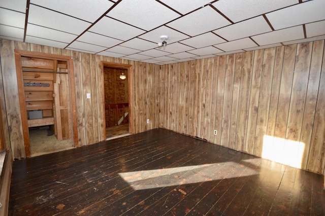 unfurnished room featuring wooden walls and hardwood / wood-style floors