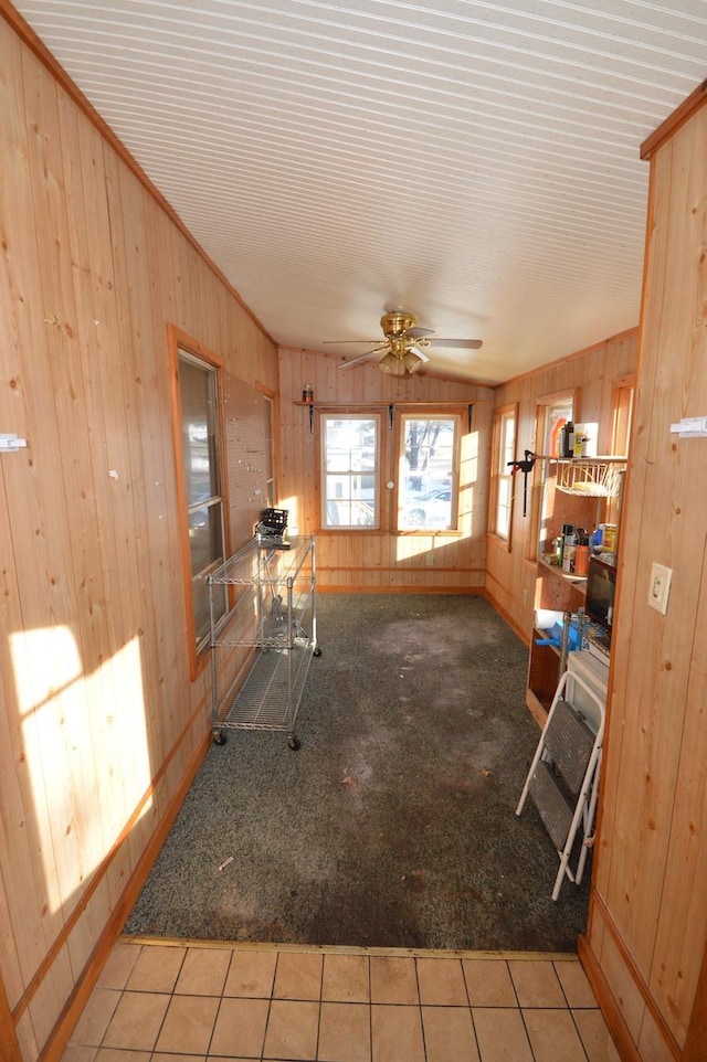 interior space with carpet, tile patterned flooring, and wooden walls