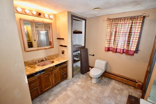 bathroom featuring a baseboard heating unit, vanity, toilet, and tile patterned floors