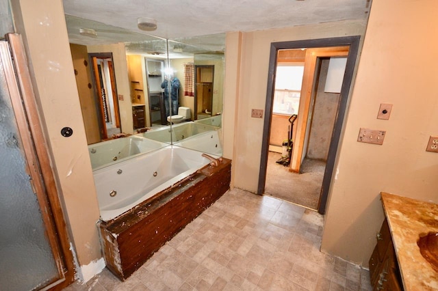 bathroom with a whirlpool tub, tile patterned floors, and vanity