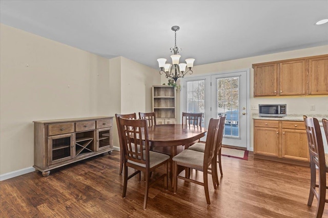 dining space with dark wood-style floors, baseboards, and a notable chandelier