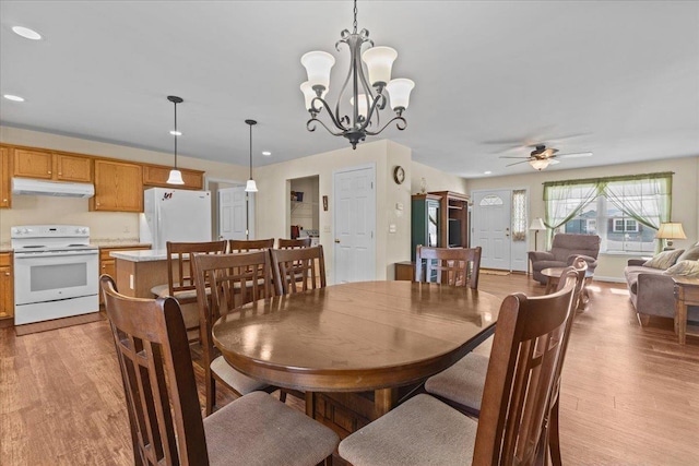 dining room featuring light wood-style floors, recessed lighting, and ceiling fan with notable chandelier