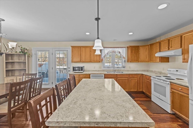 kitchen featuring a center island, dark wood-style flooring, appliances with stainless steel finishes, a sink, and under cabinet range hood