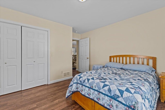 bedroom featuring baseboards, a closet, visible vents, and wood finished floors