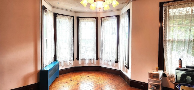 sitting room featuring ornamental molding, baseboards, and hardwood / wood-style flooring