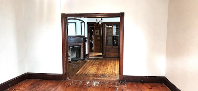 corridor with hardwood / wood-style flooring and baseboards