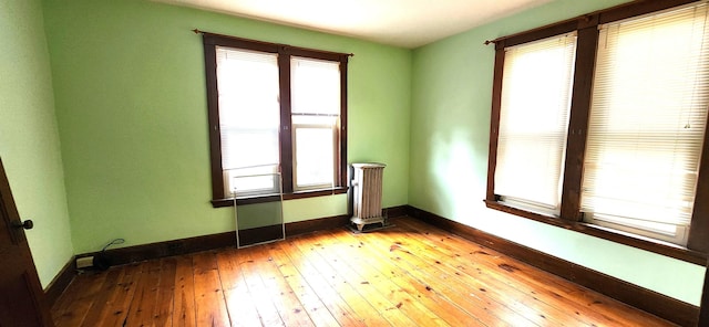 empty room featuring hardwood / wood-style flooring and baseboards