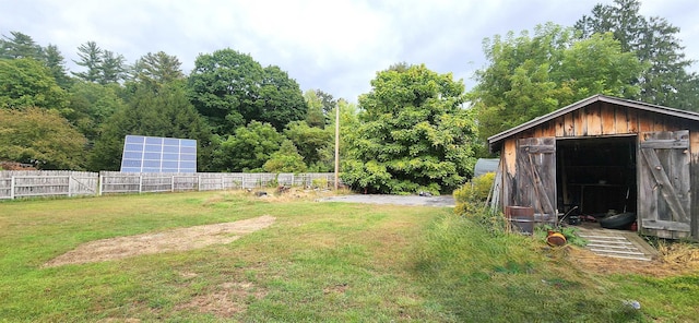 view of yard featuring a shed, fence, and an outbuilding