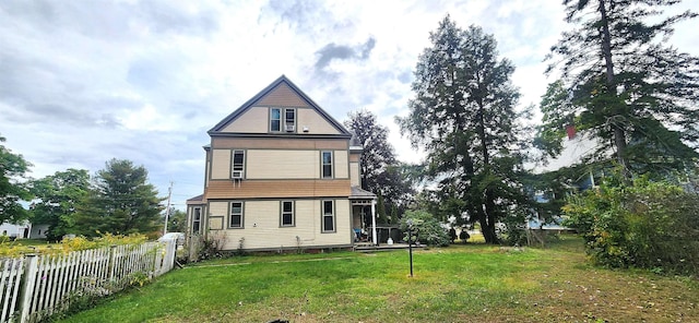 back of house featuring a lawn and fence