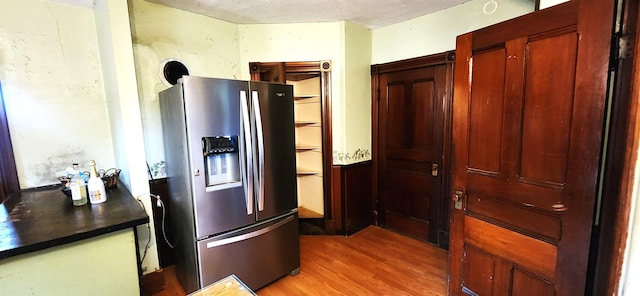 kitchen featuring dark countertops, light wood finished floors, and stainless steel fridge with ice dispenser