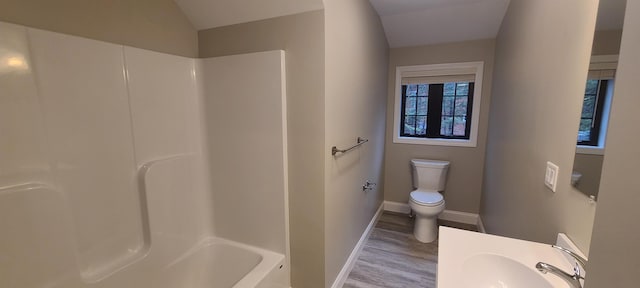 full bath featuring baseboards, a shower, toilet, wood finished floors, and a sink