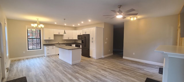 kitchen featuring a kitchen island, black fridge with ice dispenser, baseboards, open floor plan, and dark countertops