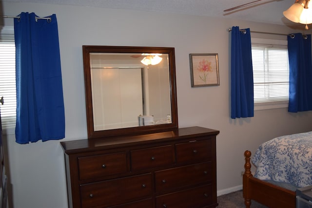 carpeted bedroom featuring a ceiling fan and baseboards