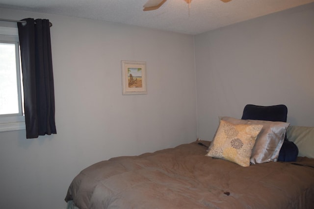 bedroom featuring ceiling fan and a textured ceiling