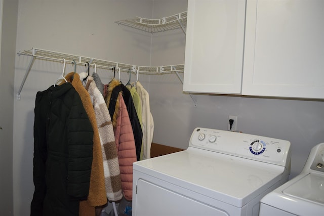 clothes washing area with cabinet space and washer and clothes dryer