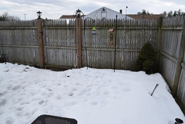 snowy yard featuring fence