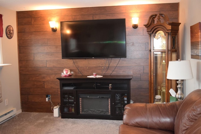 living area with a baseboard heating unit, wood walls, carpet flooring, and a glass covered fireplace