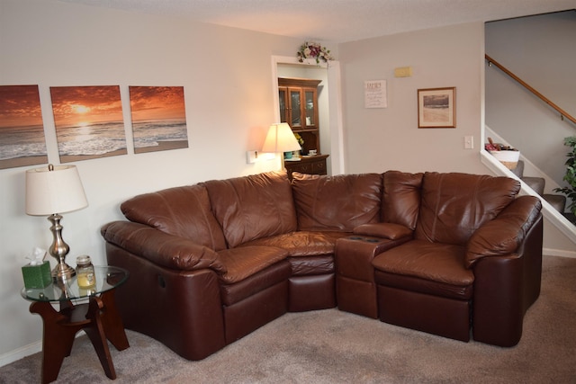 carpeted living room with stairs and baseboards