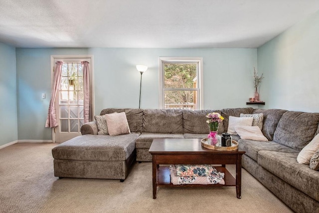 carpeted living area with a healthy amount of sunlight and baseboards