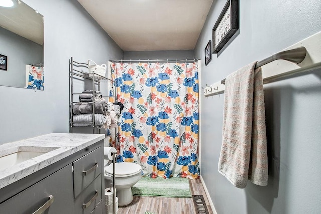 full bathroom featuring toilet, curtained shower, wood finished floors, and vanity