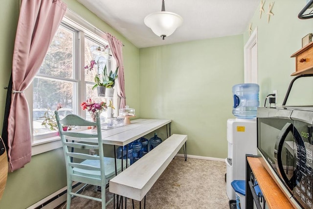 dining room with carpet floors, a baseboard heating unit, and baseboards