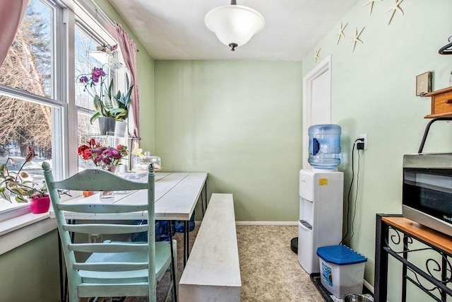 carpeted dining space featuring baseboards