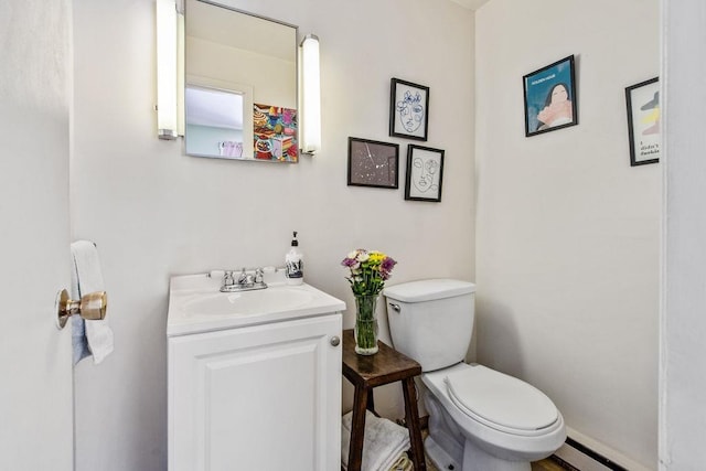 bathroom featuring a baseboard radiator, vanity, and toilet