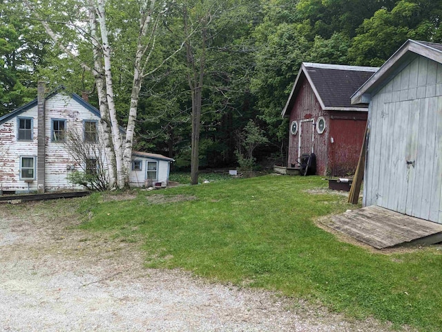 238/266 S Main St, Danby, VT 05739 - view of green lawn with an outbuilding, a storage unit, and a view of trees