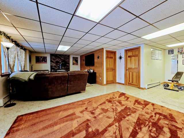 living room featuring baseboard heating, a baseboard radiator, a paneled ceiling, and baseboards