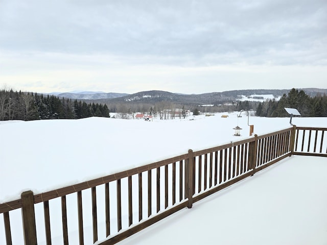 snow covered deck with a mountain view