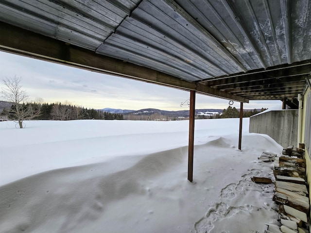 snow covered patio with a mountain view