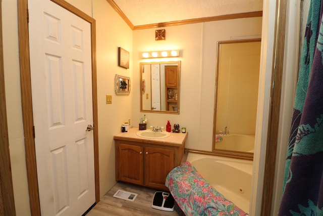 566 Baptist St, Williamstown, VT 05679 - full bath with wood finished floors, visible vents, vanity, a whirlpool tub, and crown molding