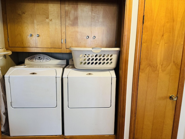 clothes washing area with cabinet space and separate washer and dryer