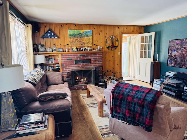 living area featuring a brick fireplace, wood-type flooring, and wooden walls