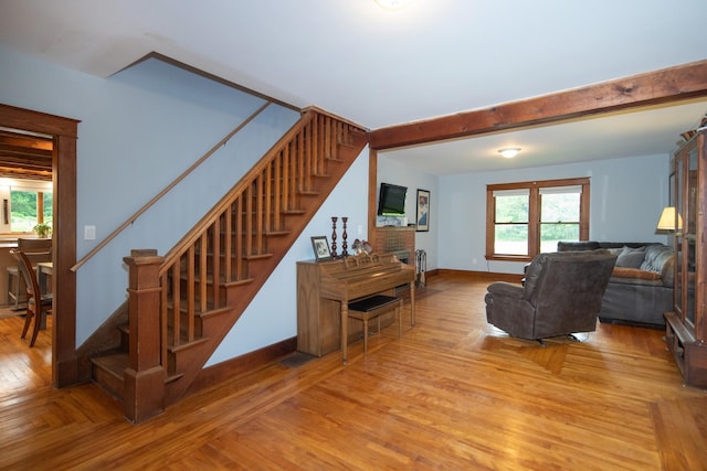 living room with beam ceiling, stairway, parquet floors, and baseboards