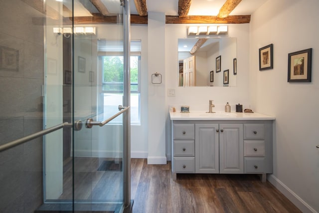 full bathroom featuring a stall shower, beamed ceiling, baseboards, and wood finished floors