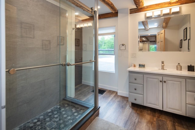 full bath featuring vanity, wood finished floors, visible vents, baseboards, and a stall shower