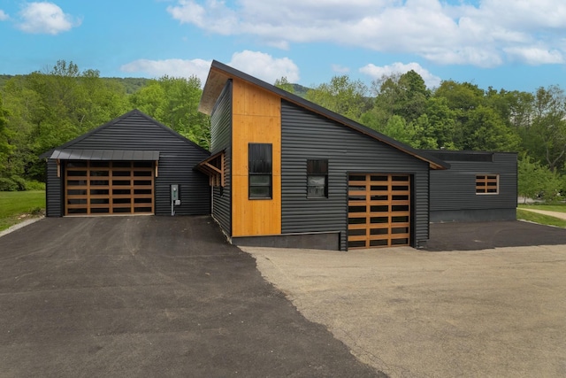 view of front of home featuring a forest view and a garage