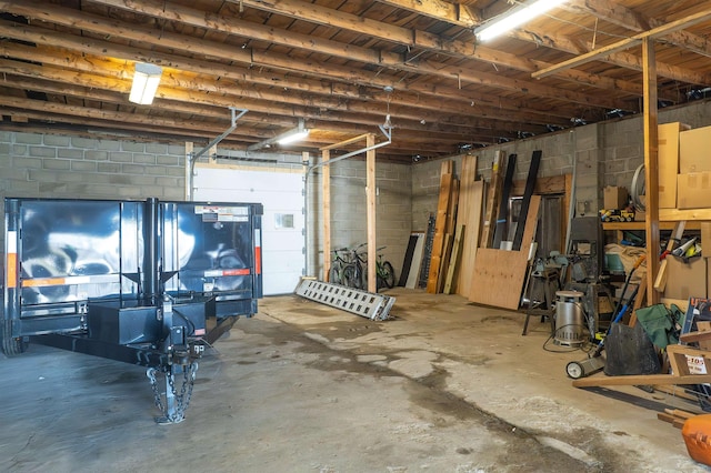 basement featuring concrete block wall and a garage