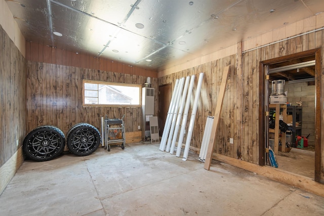 misc room with wooden walls and concrete flooring