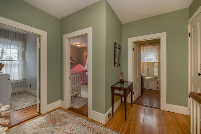 hallway with hardwood / wood-style flooring and baseboards