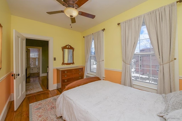 bedroom featuring a ceiling fan, baseboards, and wood finished floors