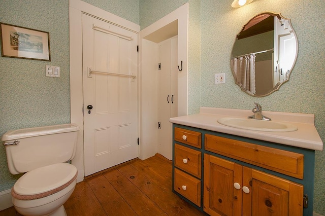 full bath featuring wallpapered walls, toilet, a shower with curtain, hardwood / wood-style flooring, and vanity