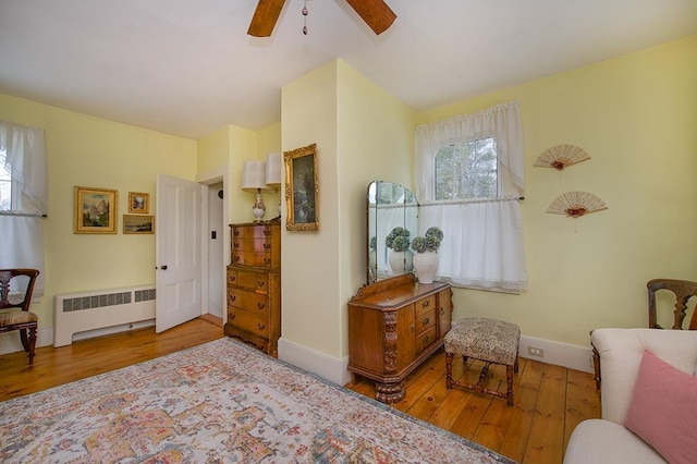 living area featuring radiator heating unit, baseboards, and wood finished floors