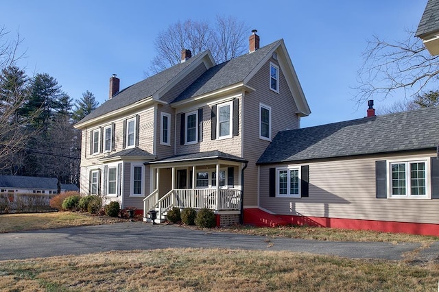 view of front of home with a chimney and a porch